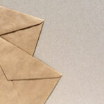 Paper envelopes on brown background with copy space